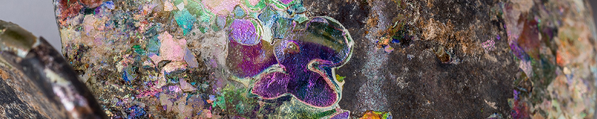 Image of a close up rock with reflective colourful elements.