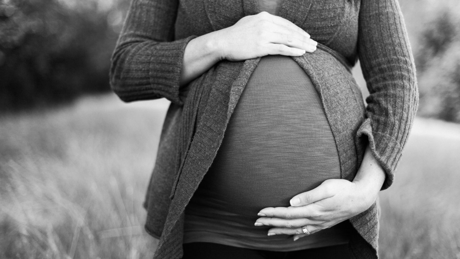 A pregnant woman holds her stomach.