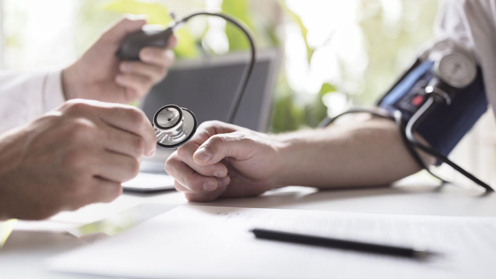 A GP measures a patient's blood pressure.