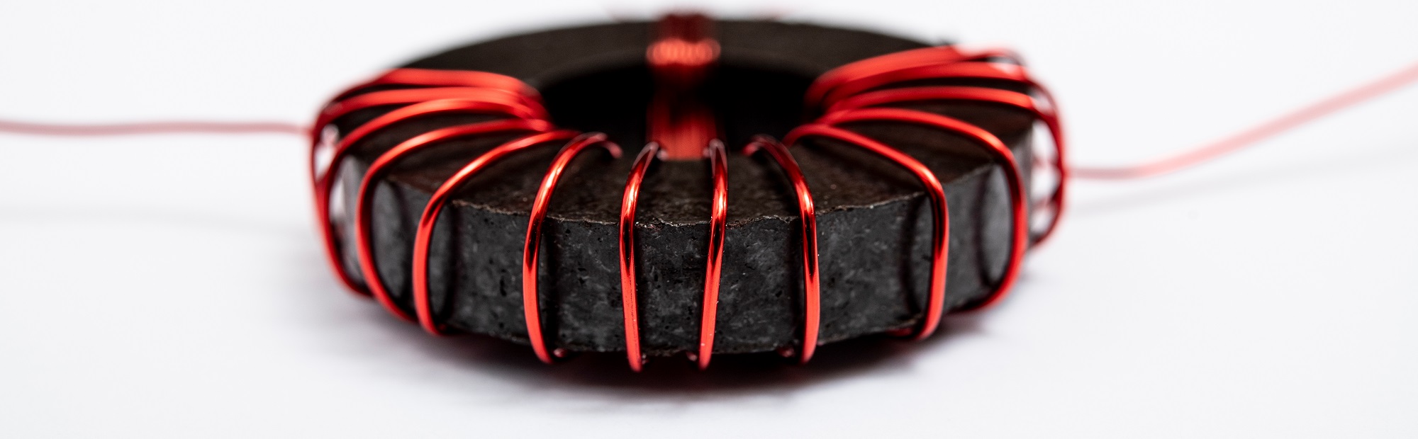 Red copper wire wound around a black ferrite core.