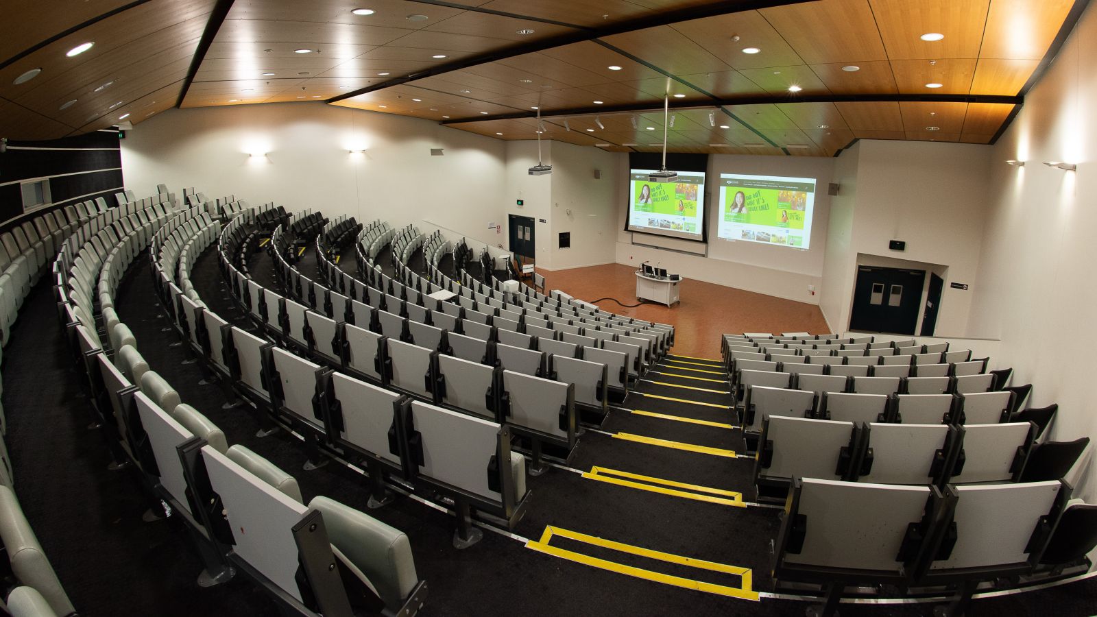 Rear view of large lecture theatre in Rutherford House, with screens and lectern with computer visible