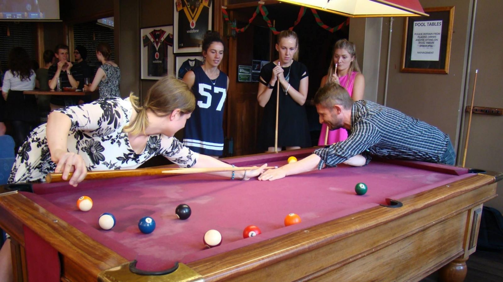 Students playing pool at Italian bar.