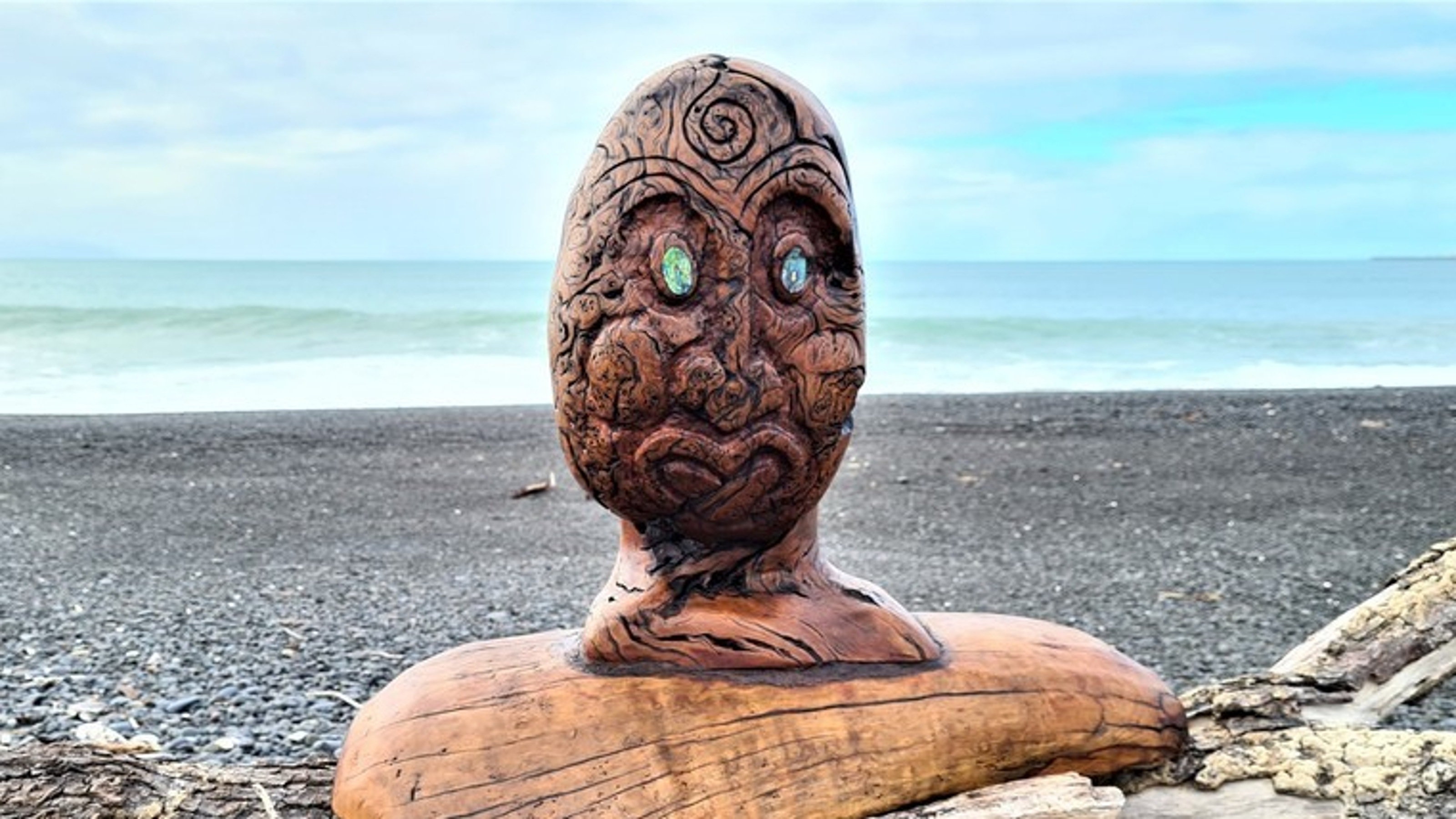 The Spirit Award trophy sits on a log on a beach