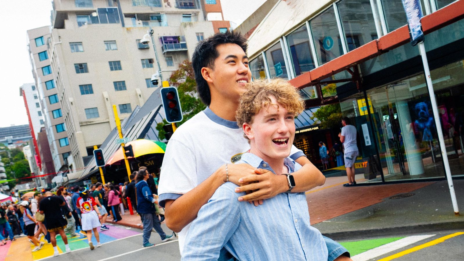 Two guys on Cuba street, one giving the other a piggy back