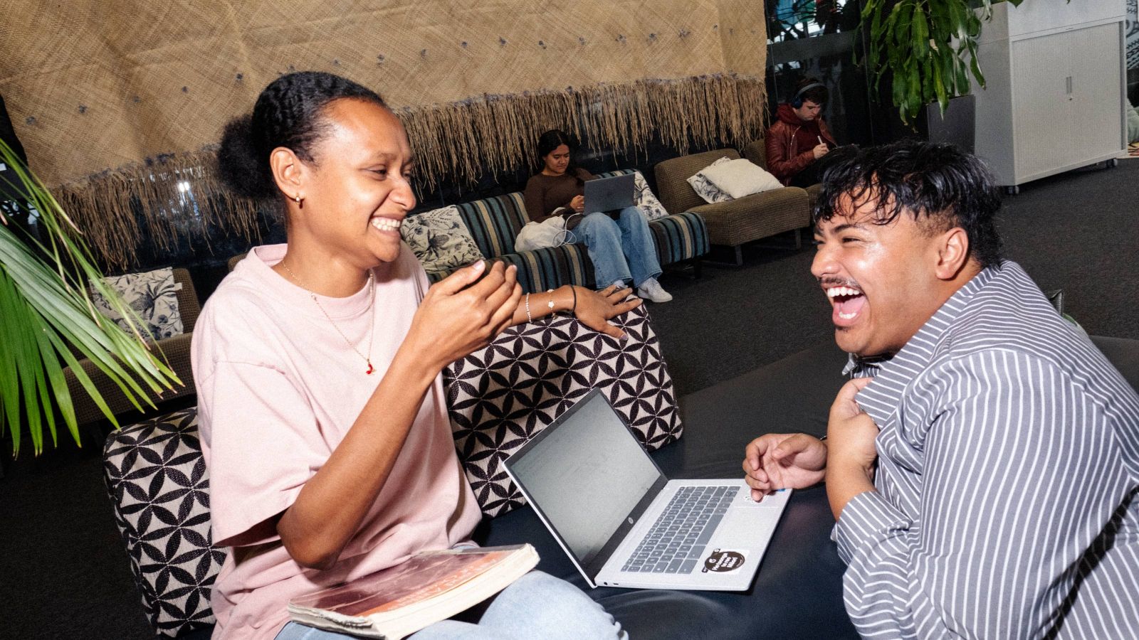 two students studying and laughing in the Pasifika study area
