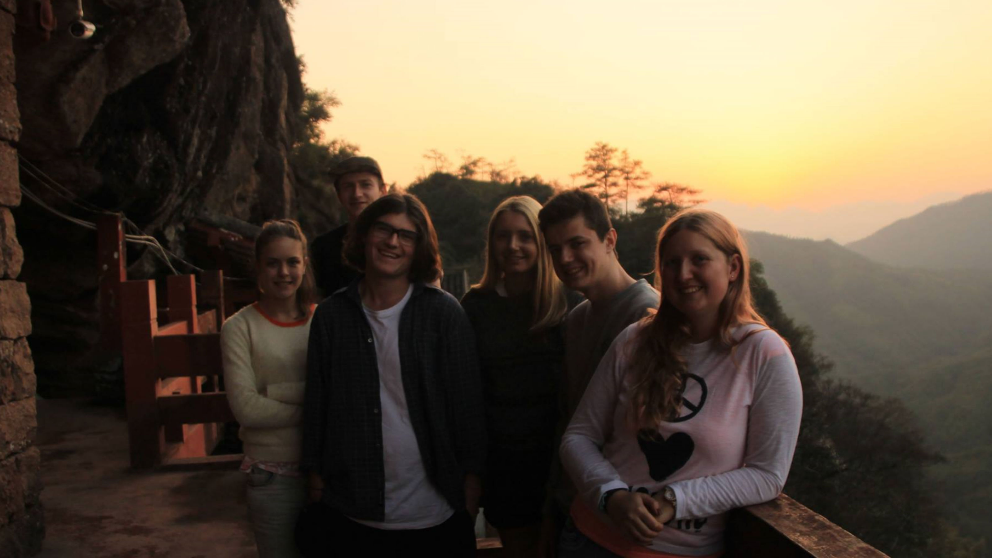 Victoria student, Brady, with a group of international students in China, standing in front of a setting sunscape.