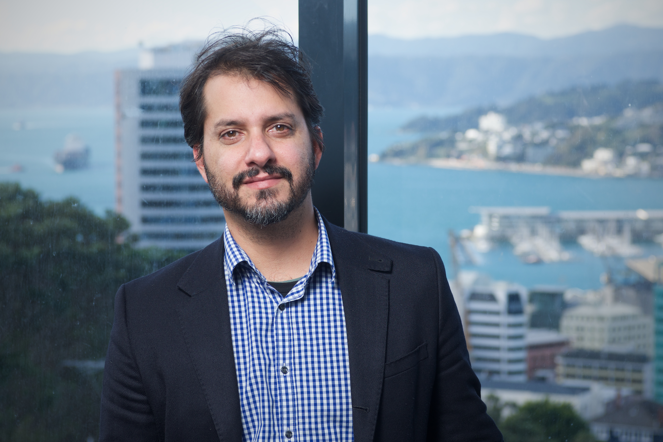 Dr Taciano Milfont looking into the camera with Wellington city and harbour in the background