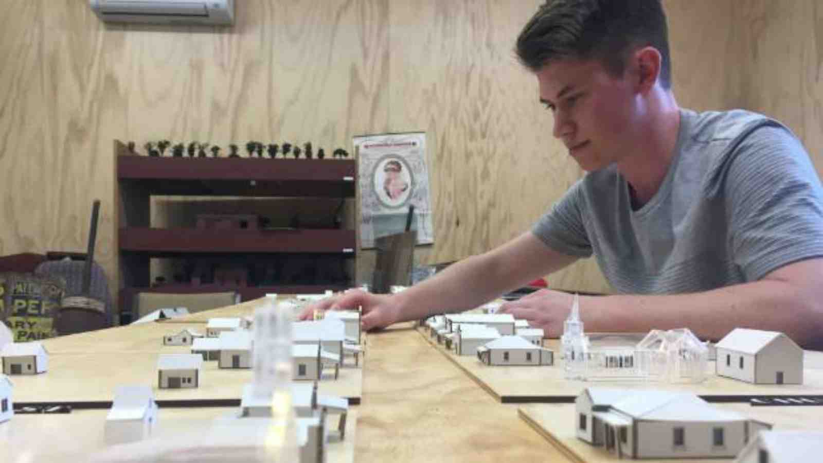 Thomas Nieuwenhuis sits with architectural model of Greytown he has created – Photo credit: Illya McLellan/Stuff.