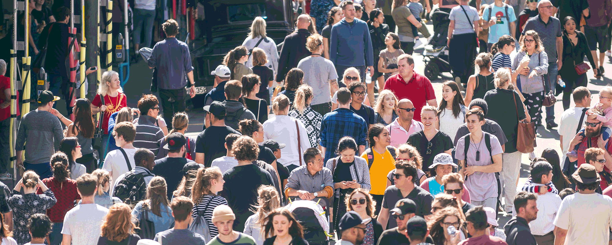 Pedestrians walk in various directions on a closed street. 