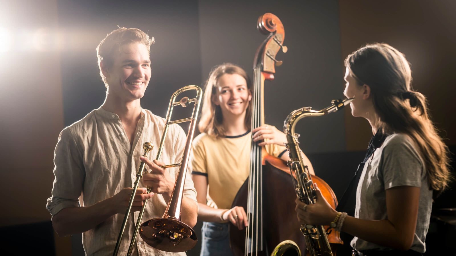 Three students playing instruments at the New Zealand School of Music.