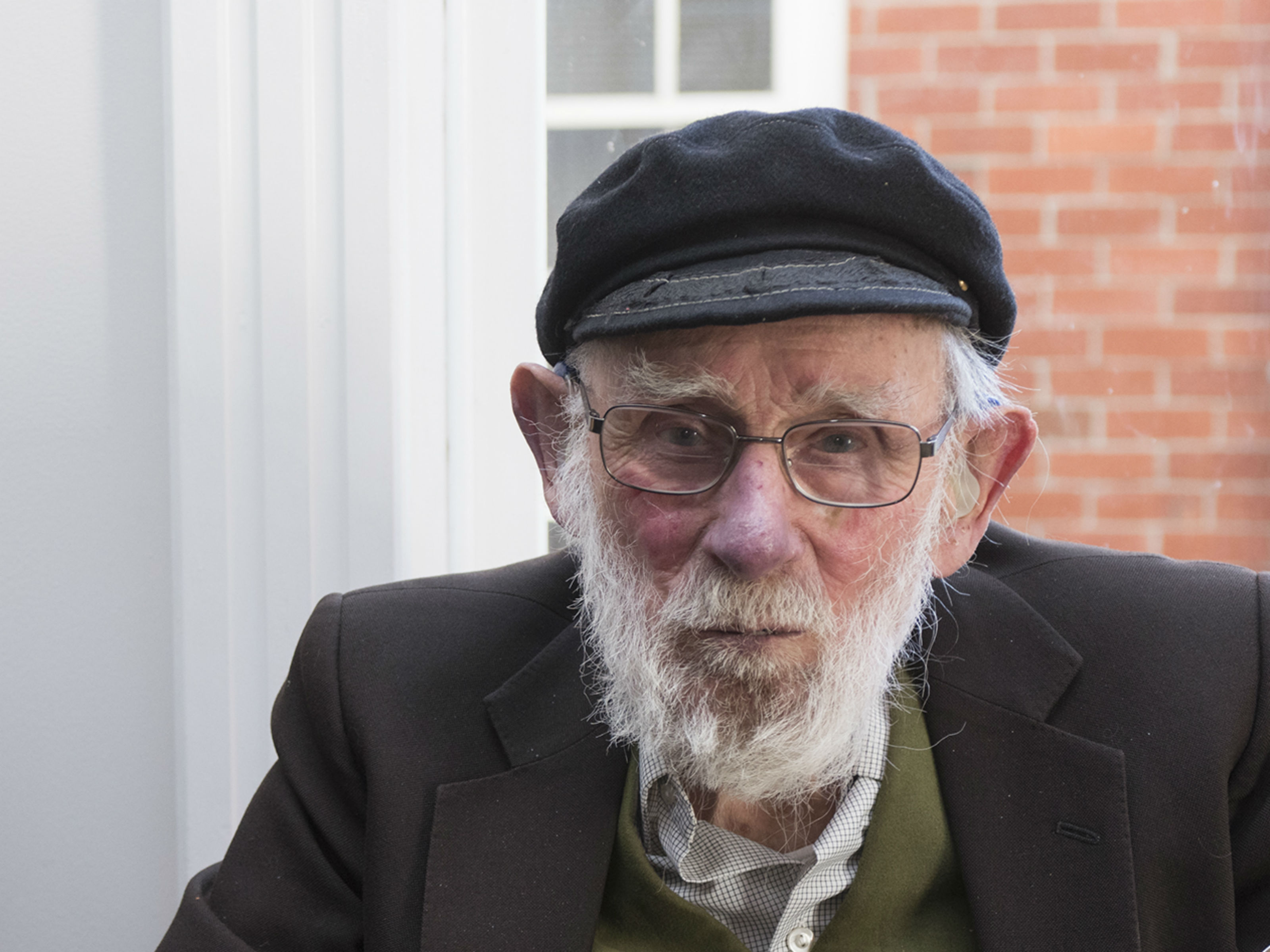 Arnold Heine in glasses and a black cap.