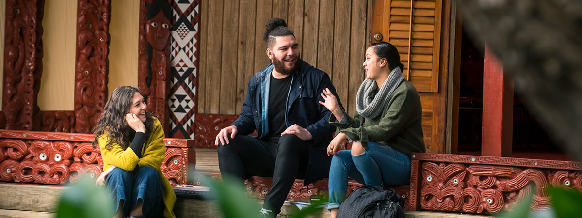 Students in discussion sitting outside of the Marae. banner image