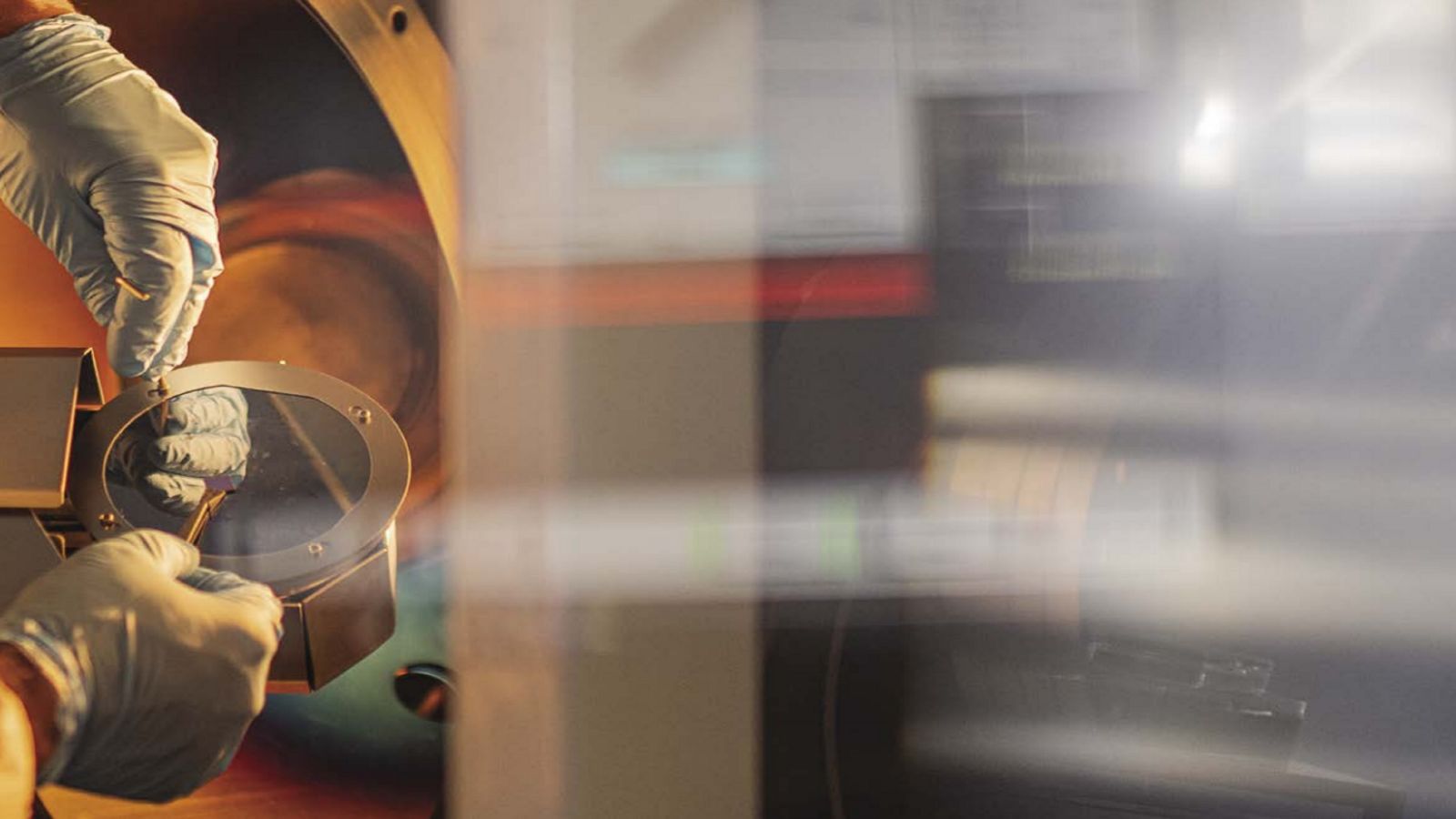 Gloved hands working on a machine with tools