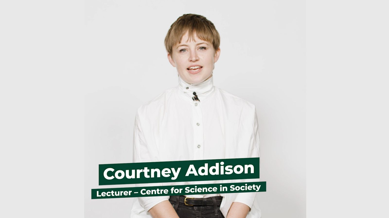 Lecturer Courtney Addison stands facing the camera against a white background