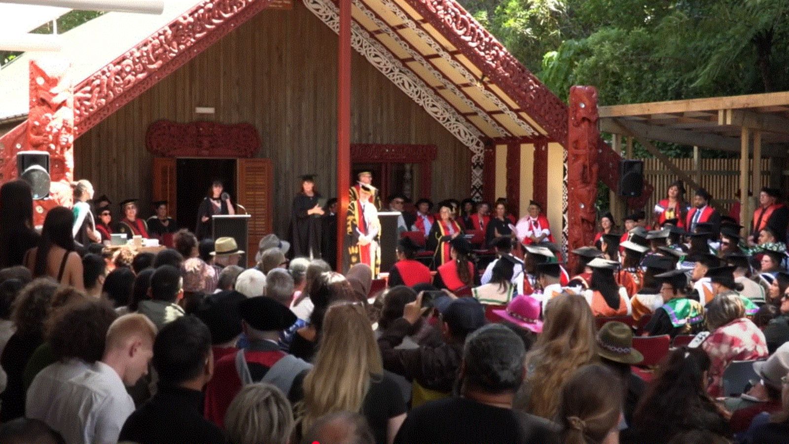 A crowd of people gathered outside a marae.