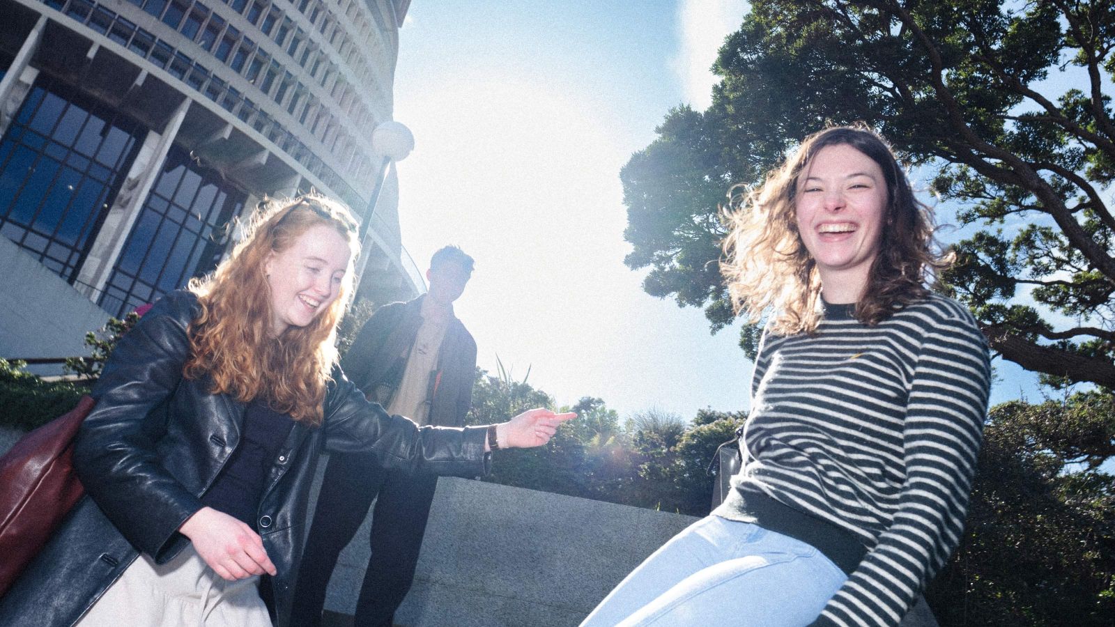 3 students on stairs outside Beehive