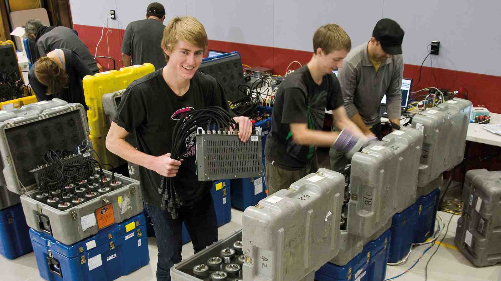 Victoria University postgraduate students prepare seismometers for deployment in specially dug holes in the coast-to-coast project