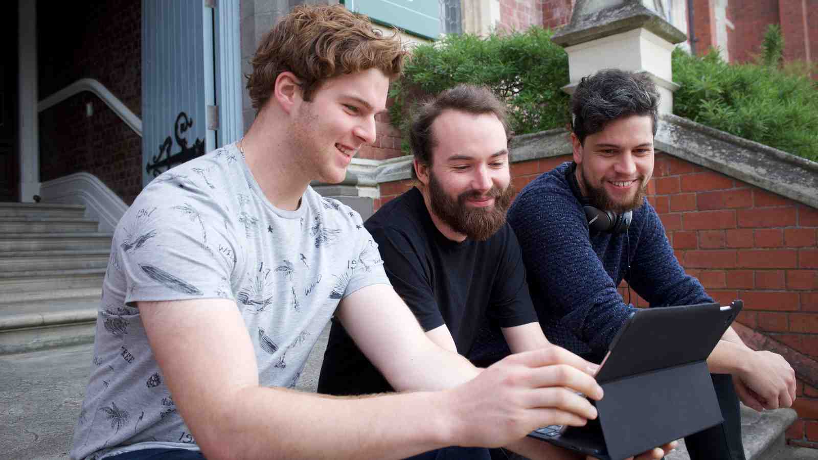 Masters students from the New Zealand School of Music students sitting outside on the Hunter building steps