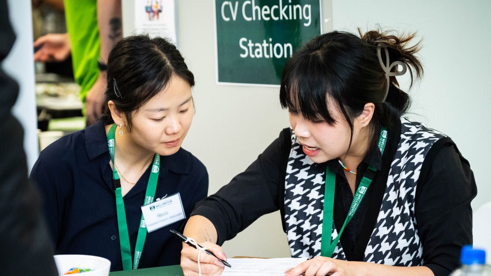 Blonde female careers consultant discussing a CV with Hijabi student in denim jacket