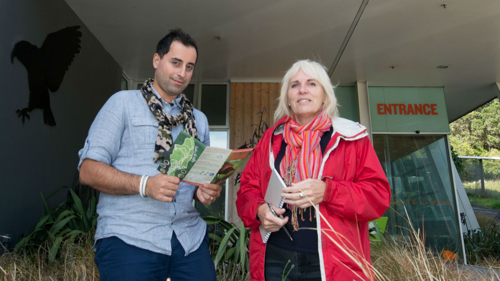 Bruno Marques and Jacqueline McIntosh stand together amoung shrubs at the entrance of Zealandia.