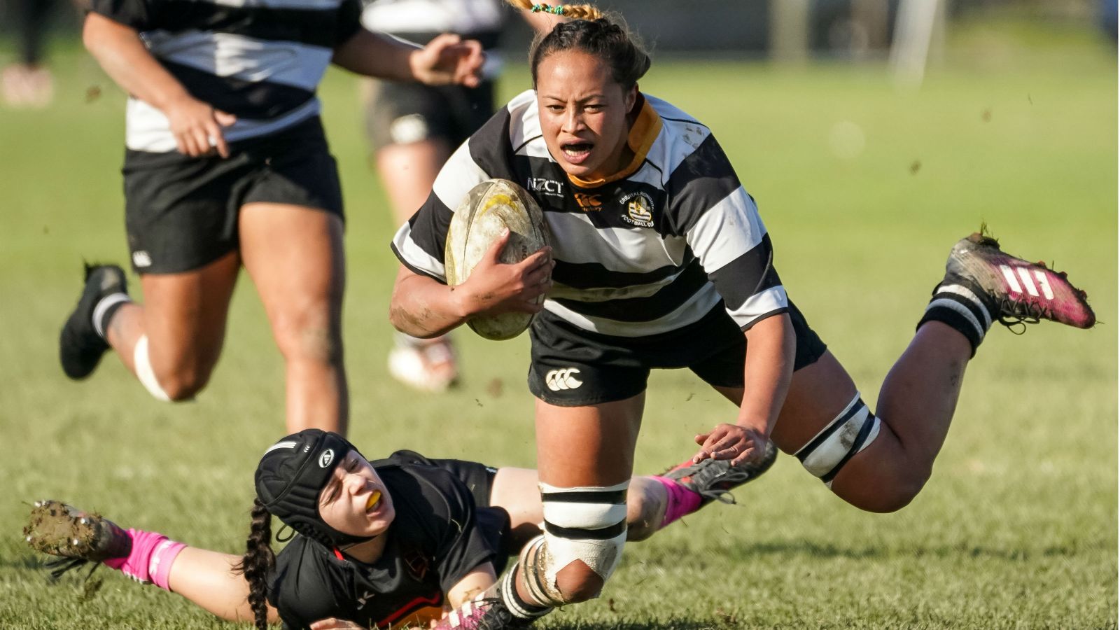 Joanah Ngan-Woo in possession of the ball gets tackled round the legs in a game of rugby.