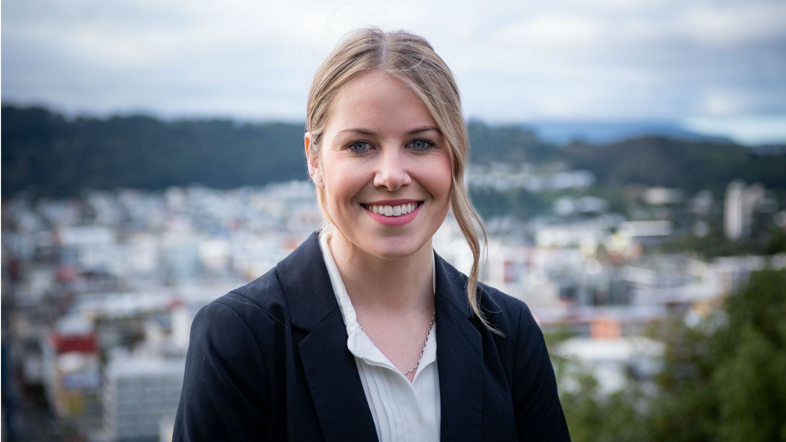 Laurette Siemonek stands outside with Wellington city behind her