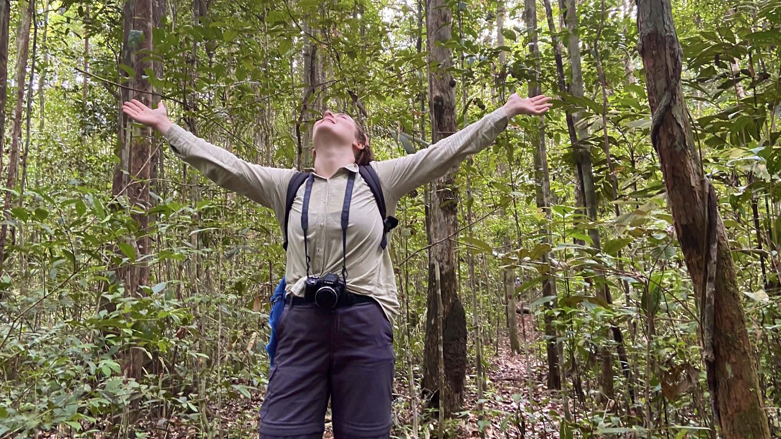 Rochelle Tait raises her hands in the Amazon rainforest.