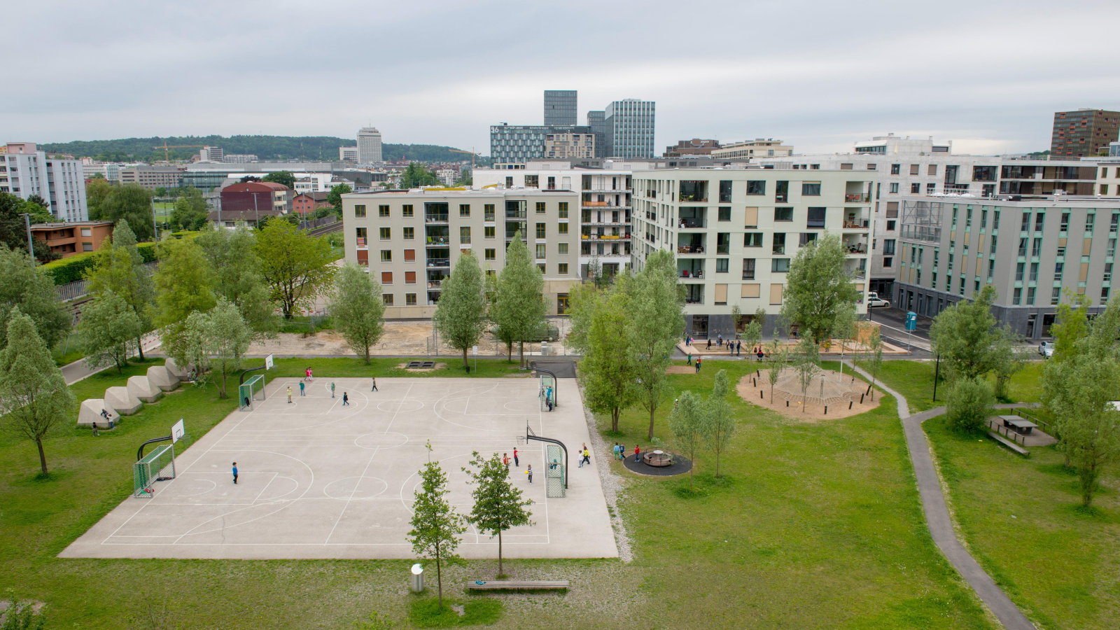 apartment building with green grass and basketball out front