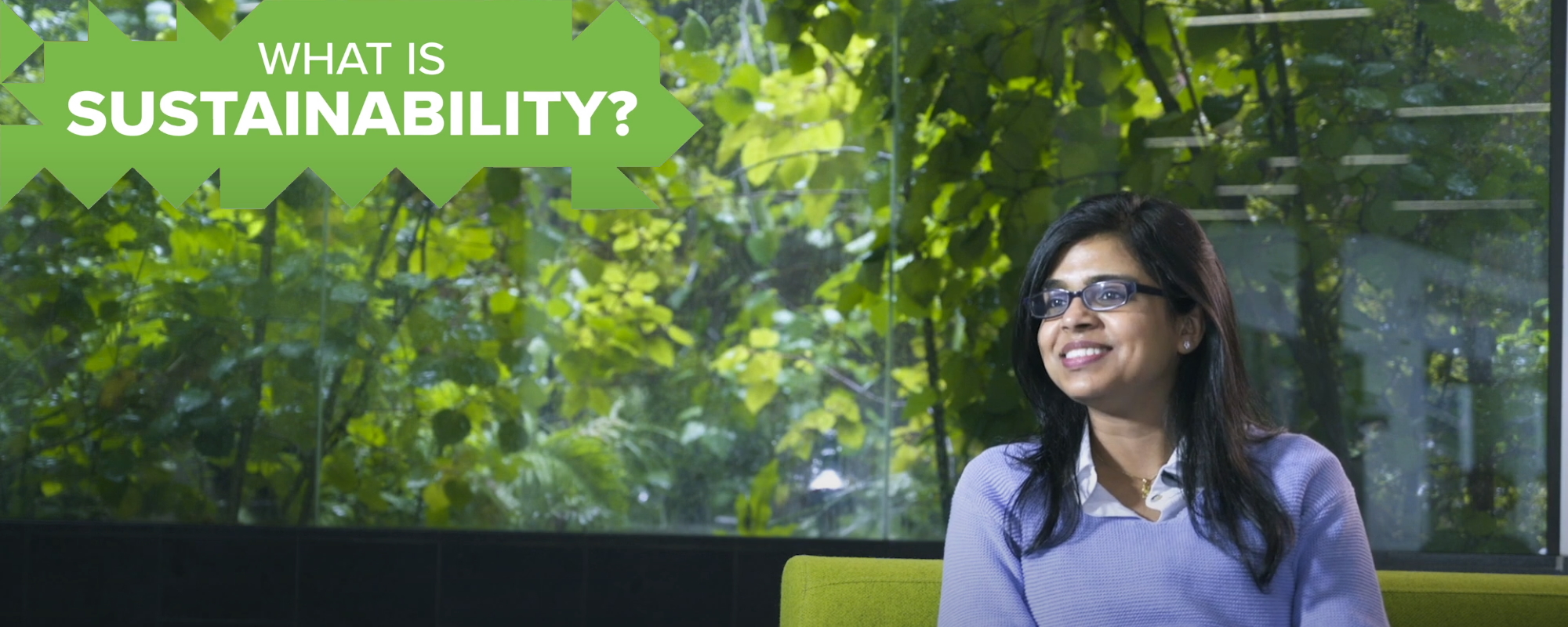Video still:  Dr Shalini Divya talking, with a leafy background.