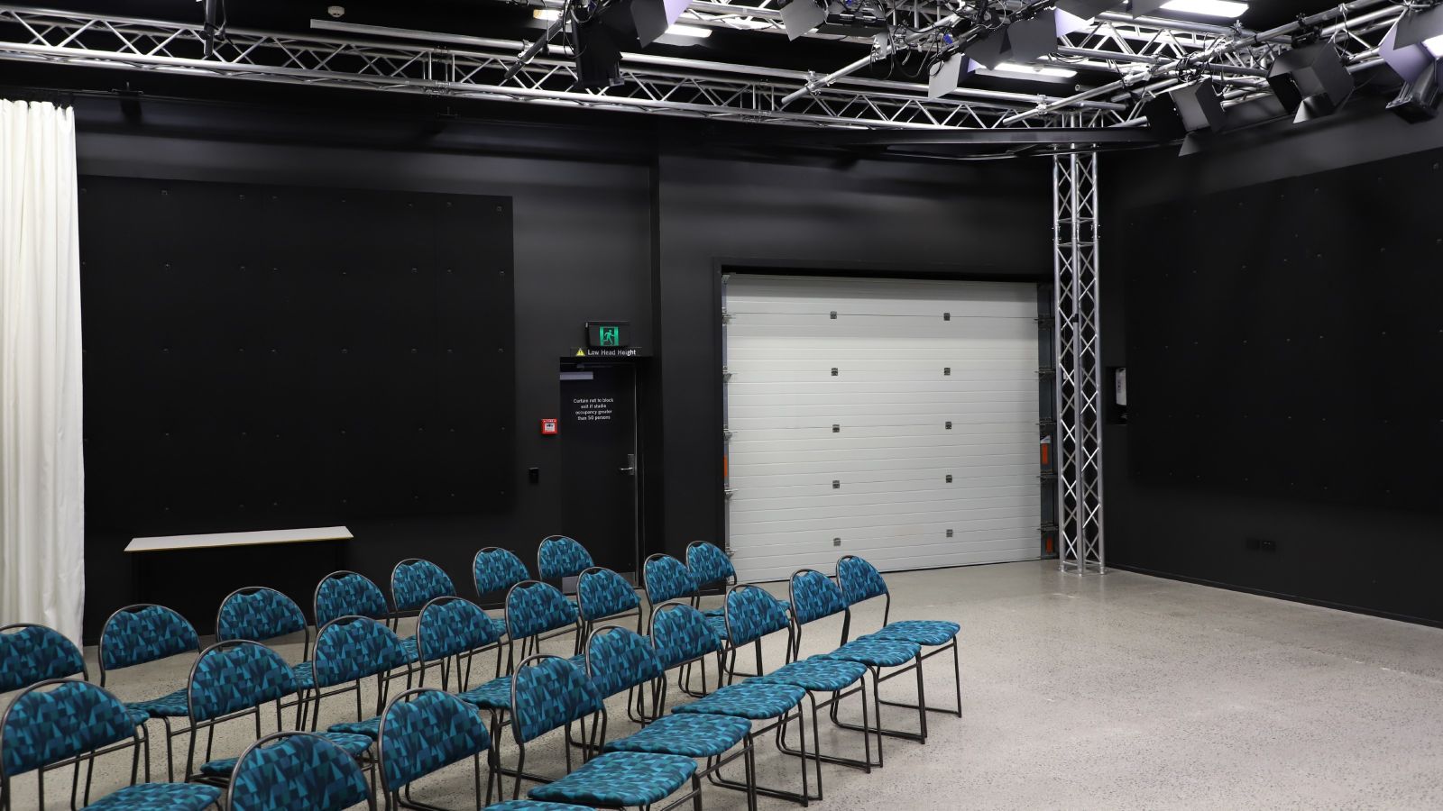 Film studio with TV screen and blue chairs in rows