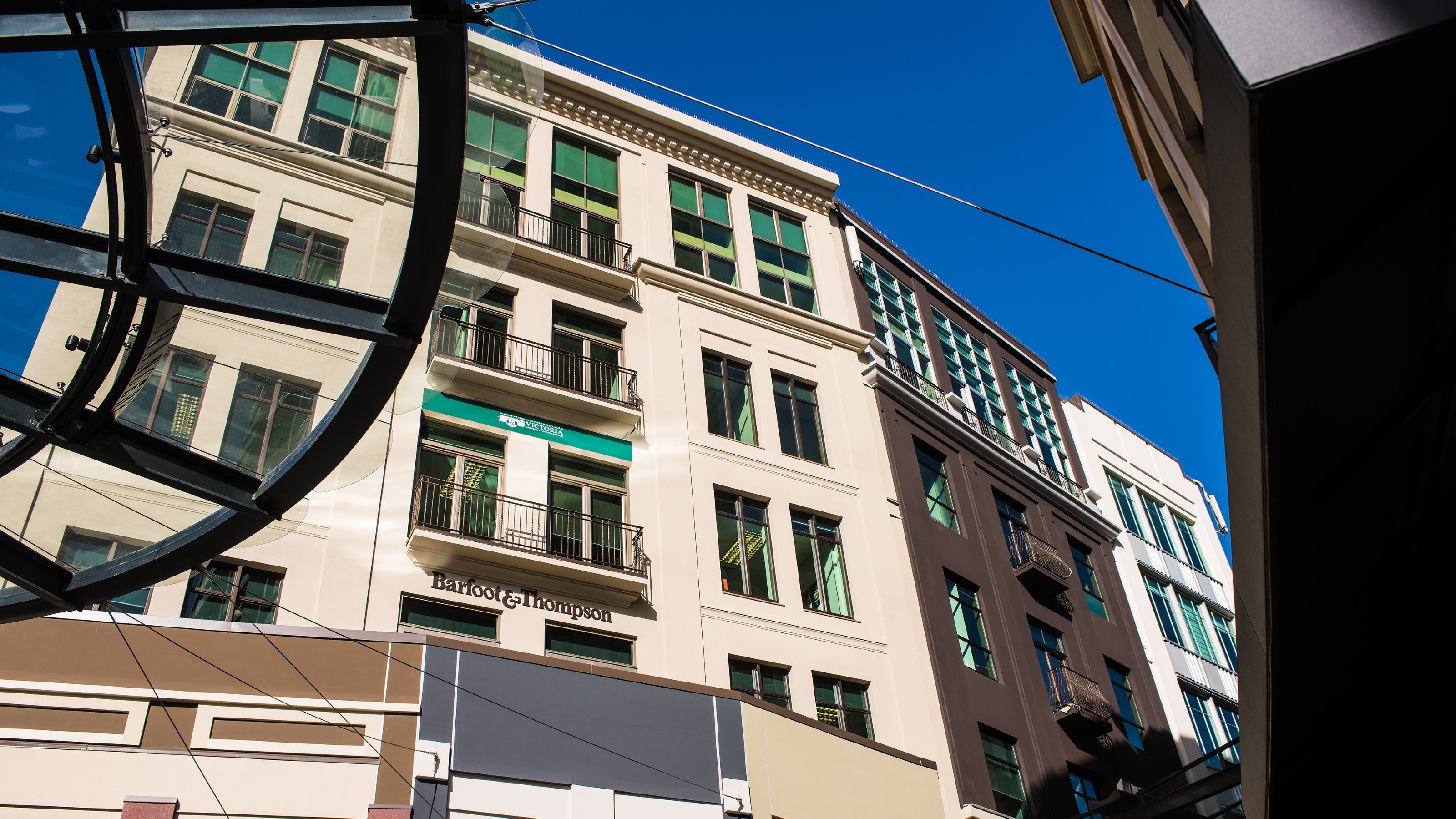 Bottom-up view of the Auckland building, a tall beige building.