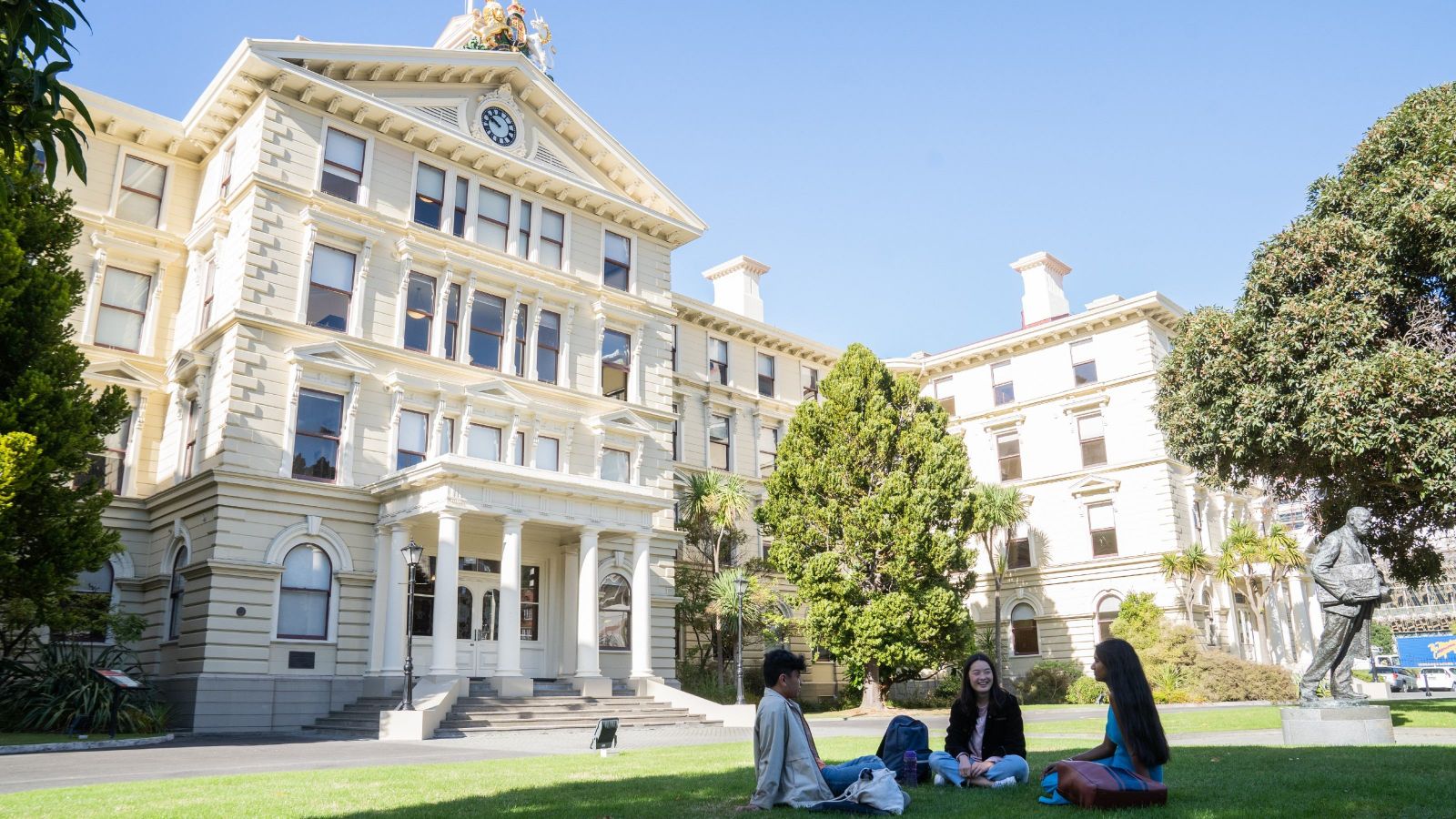 Image of the faculty with students sitting on the lawn.