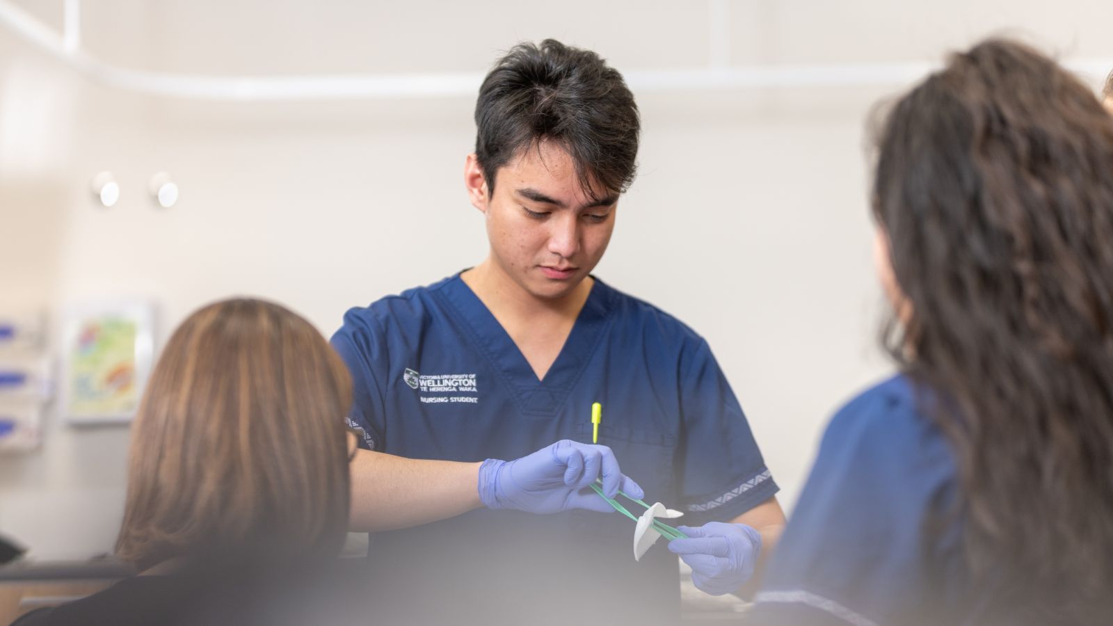 Nursing student wearing scrubs and gloves 