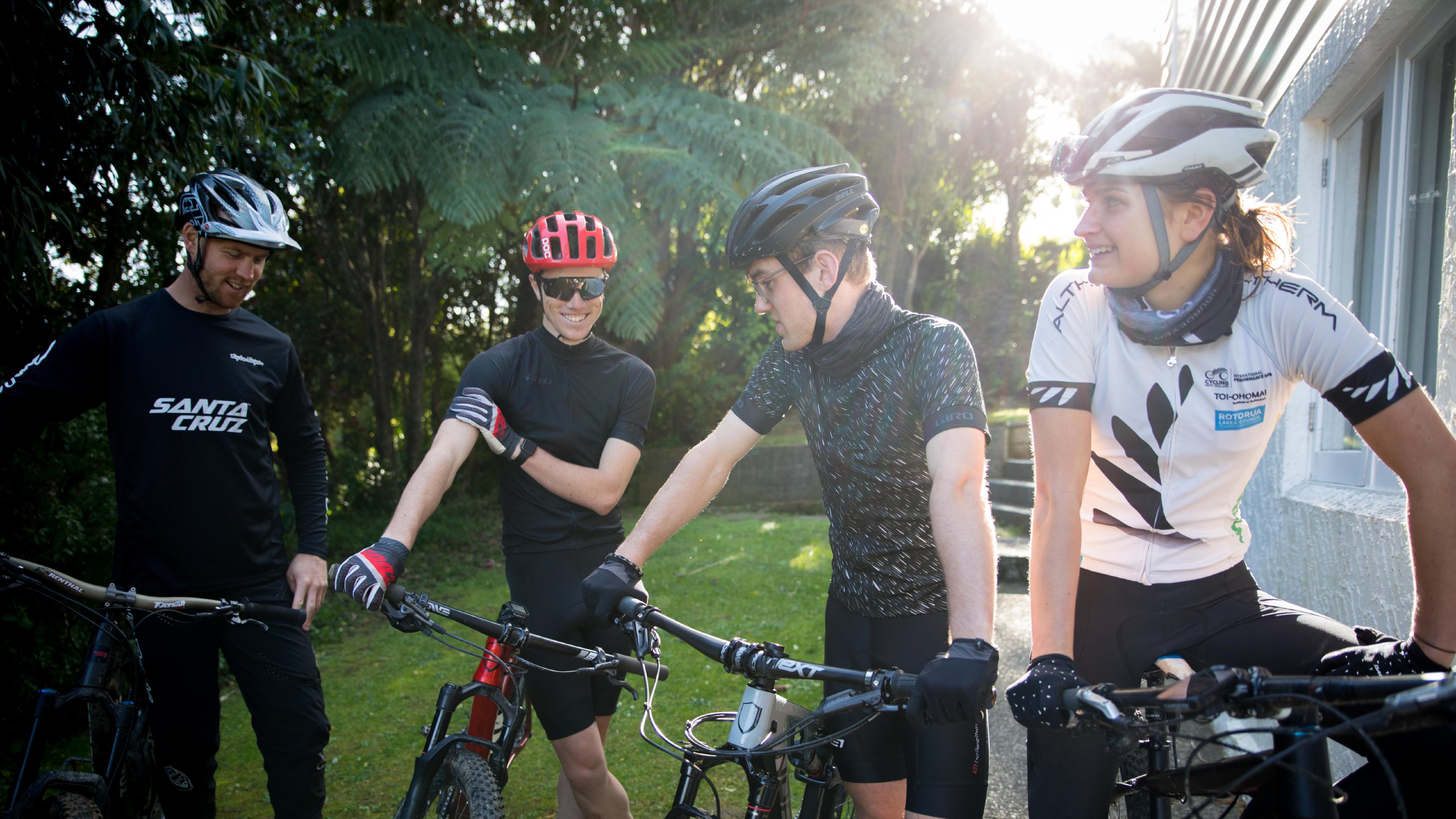 Four students with their mountain bikes, wearing helmets and cycling gear.