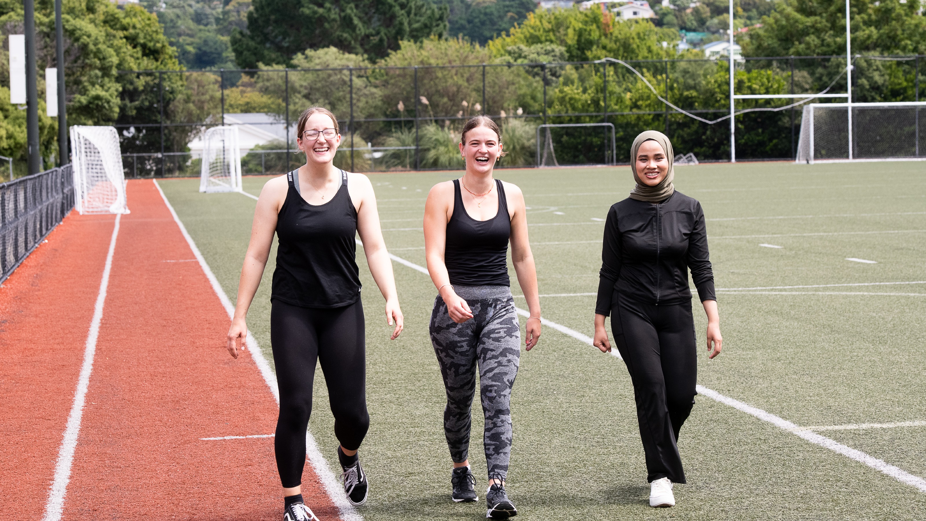 Group of students walking on campus on a sunny day.