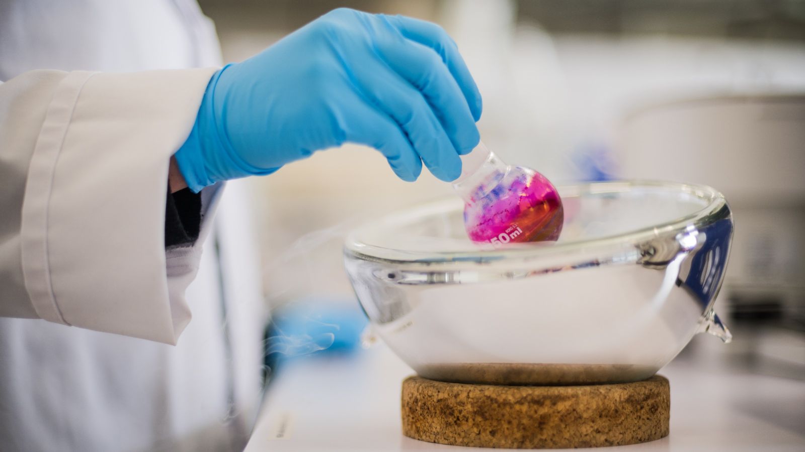 Person in lab coat conducting a scientific experiment with chemicals