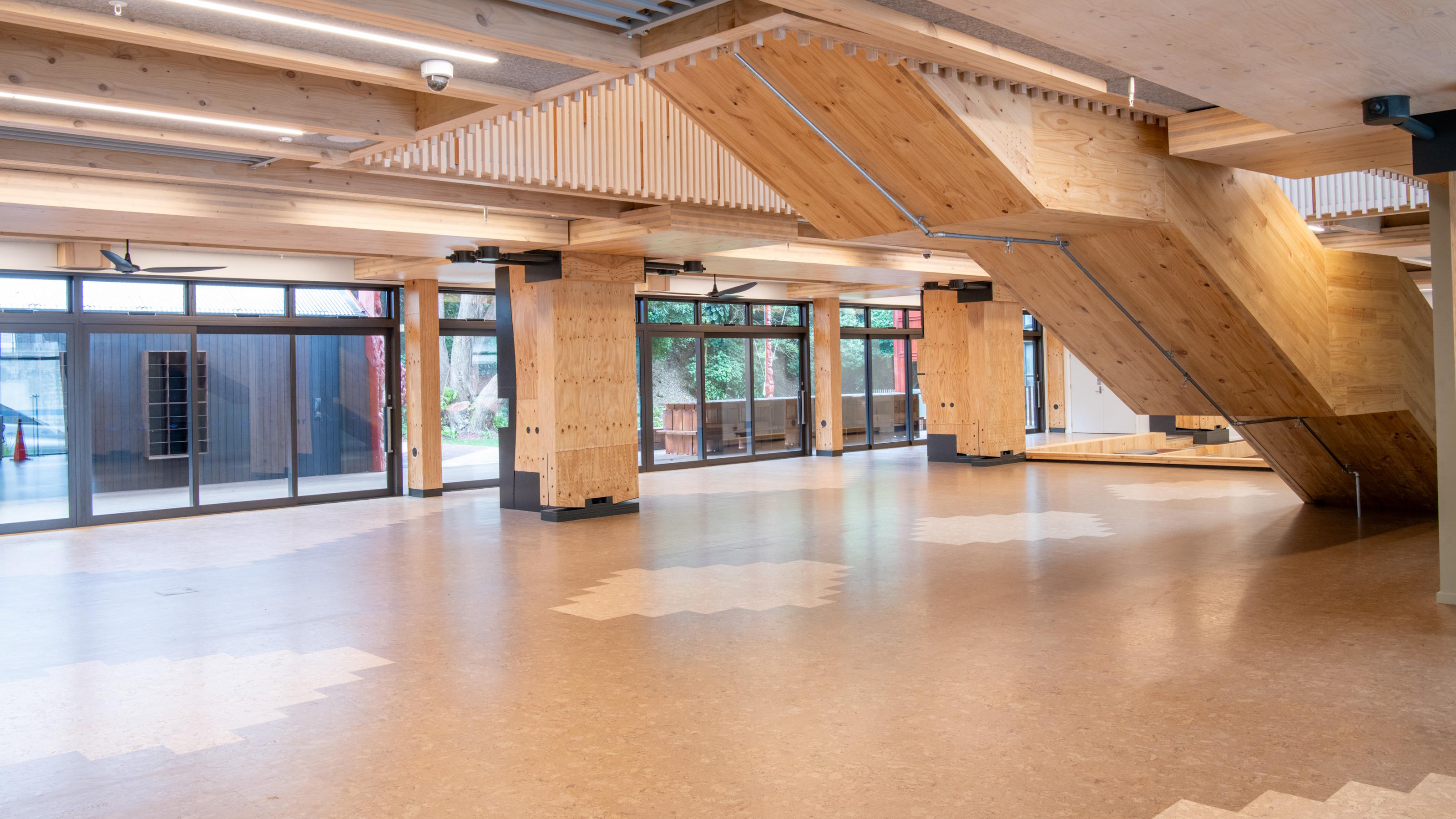Large open space within building with timber floor and pillars