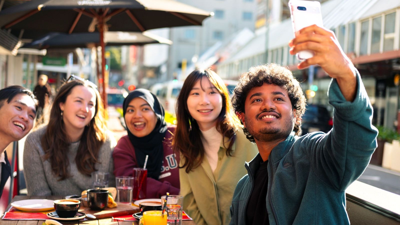 Students taking a selfie at a city cafe