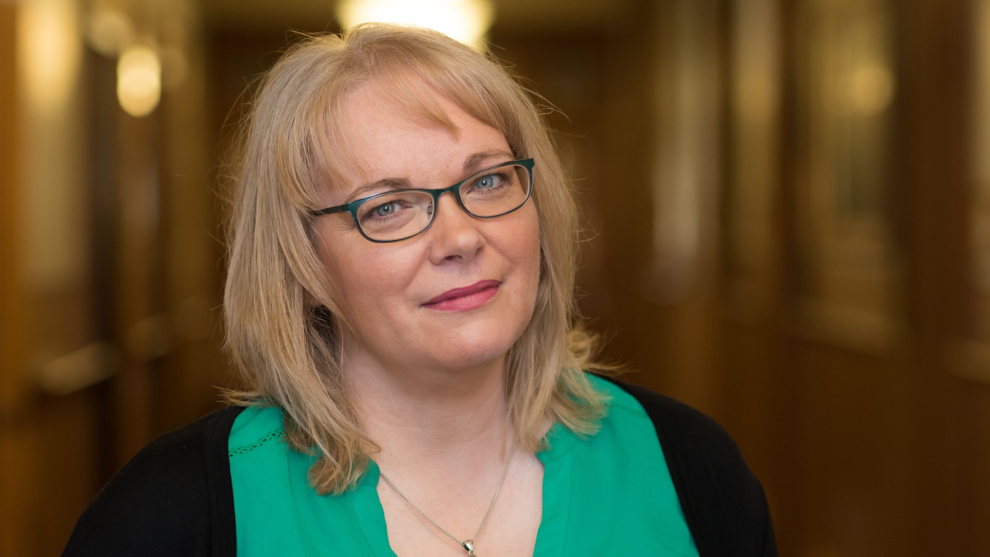 Professor Yvette Tinsley standing in a blurred hallway. 