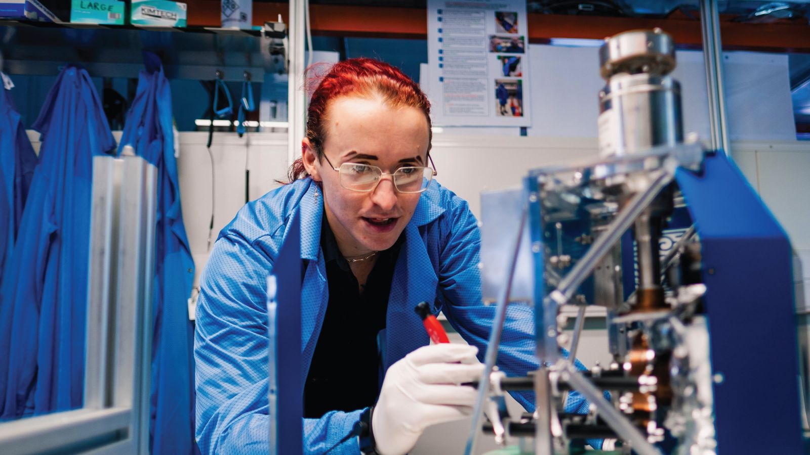 Student studying in a lab wearing a blue lab coat