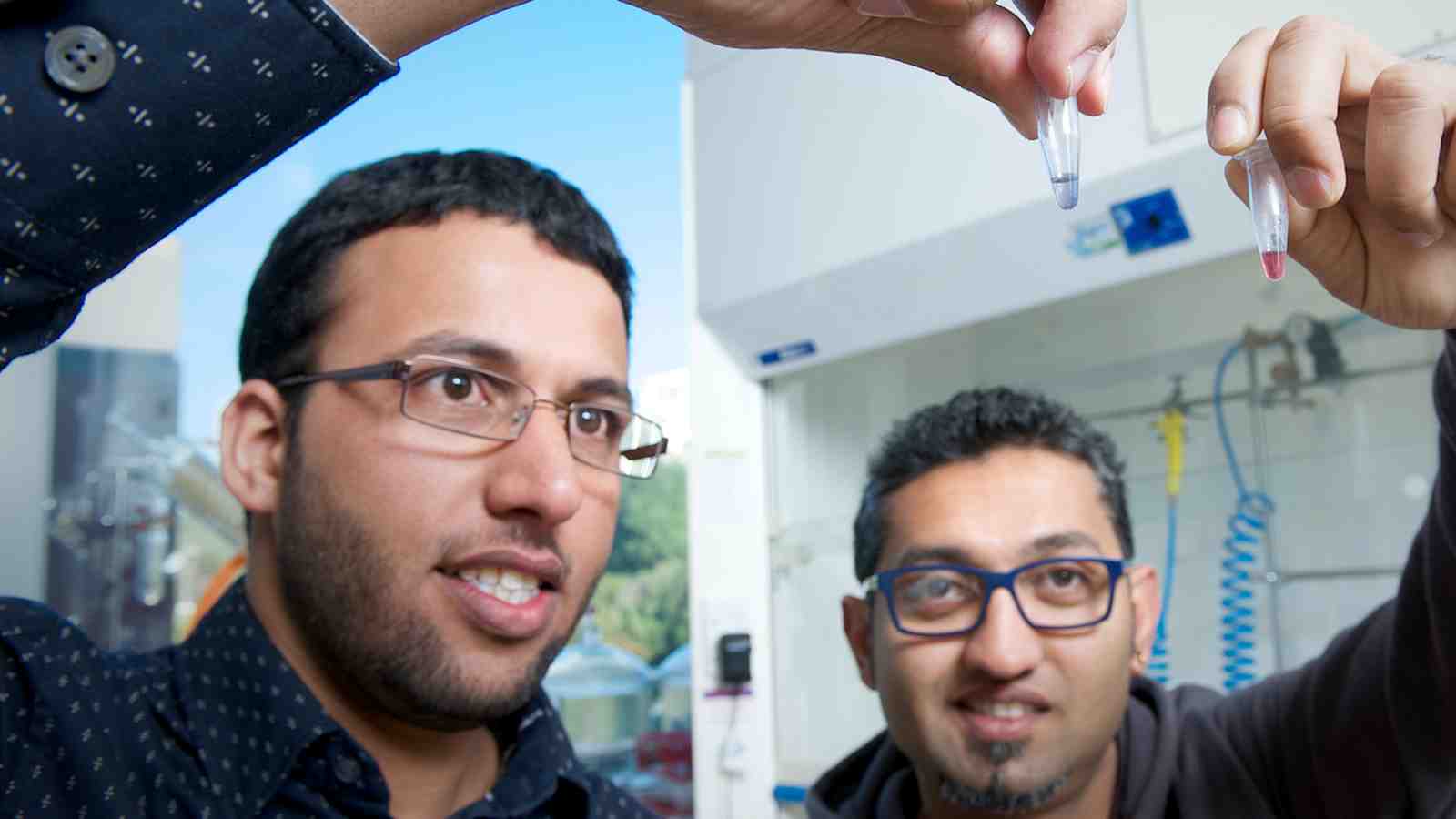 PhD students Shalen Kumar and Omar Alsager look at test tubes