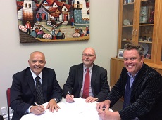 UVM’s Carlos Ramirez (left) signing the agreement with Victoria University Professors Roberto Rabel and Warwick Murray