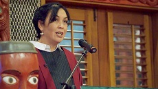 Professor Rawinia Higgins giving speech at lectern at Marae