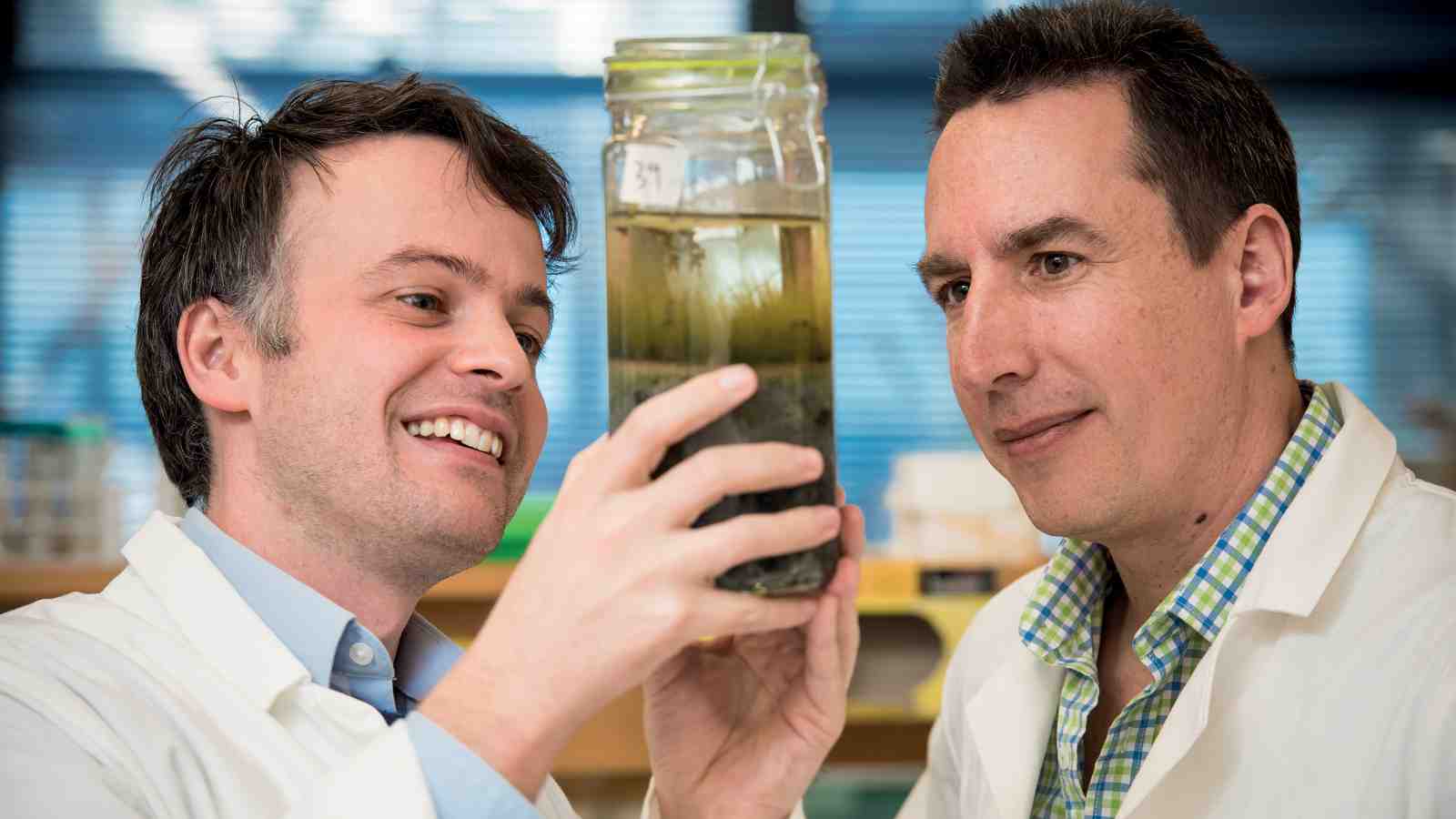 Dr Jeremy Owen and Associate Professor David Ackerley in the research lab looking at a specimen in a jar