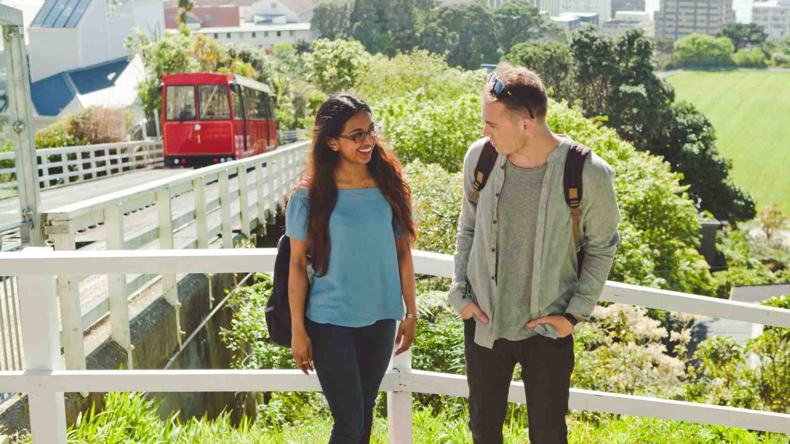 Two university students standing and talking near the cable car in Wellington.