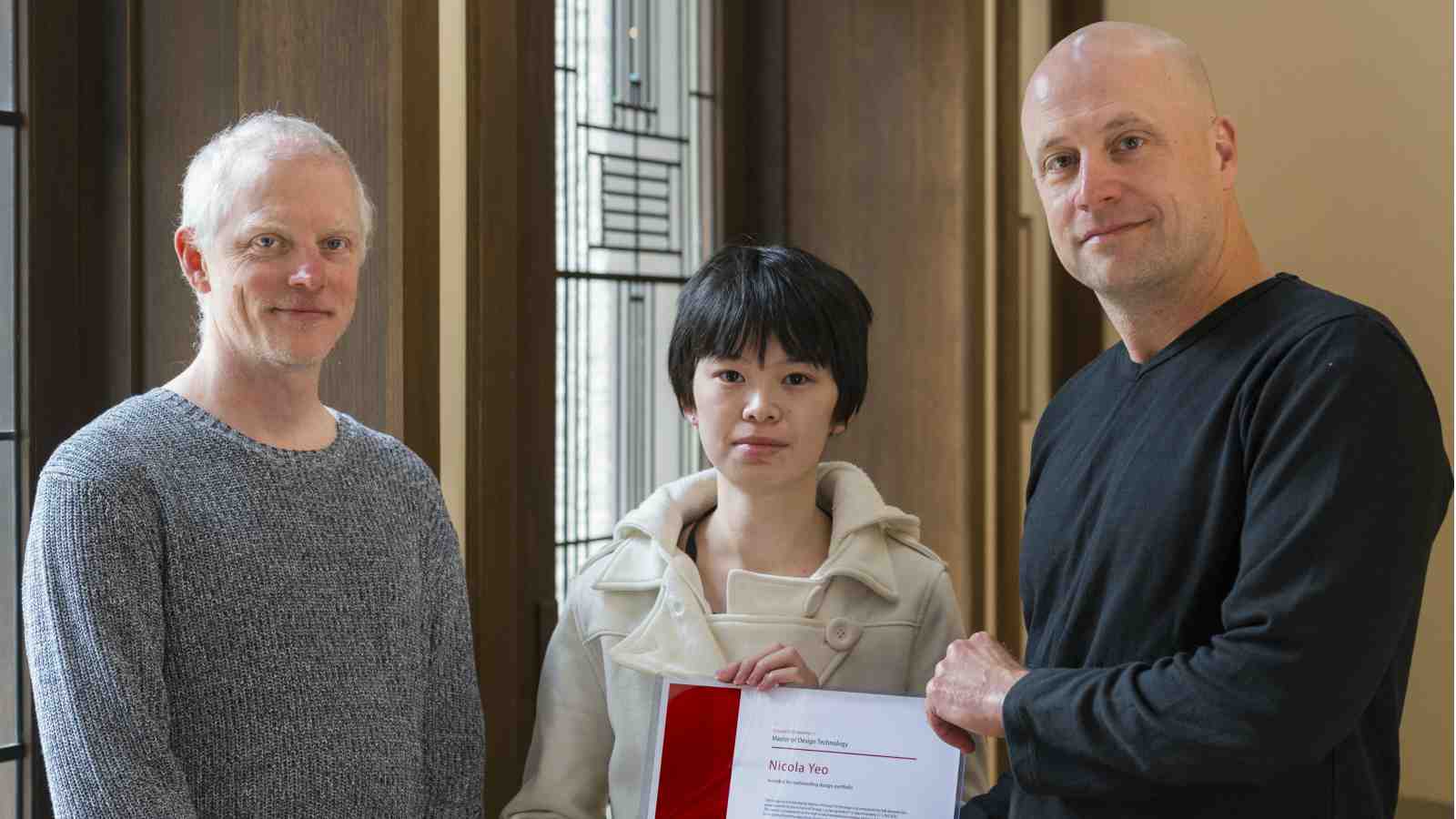 Doug Easterley handing Nicola Yeo a certificate for her scholarship, Kevin Romond stands to the left.