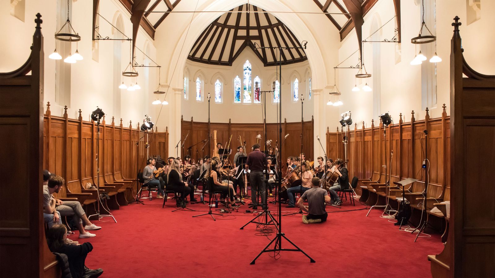 Orchestra on a red carpet in a church.