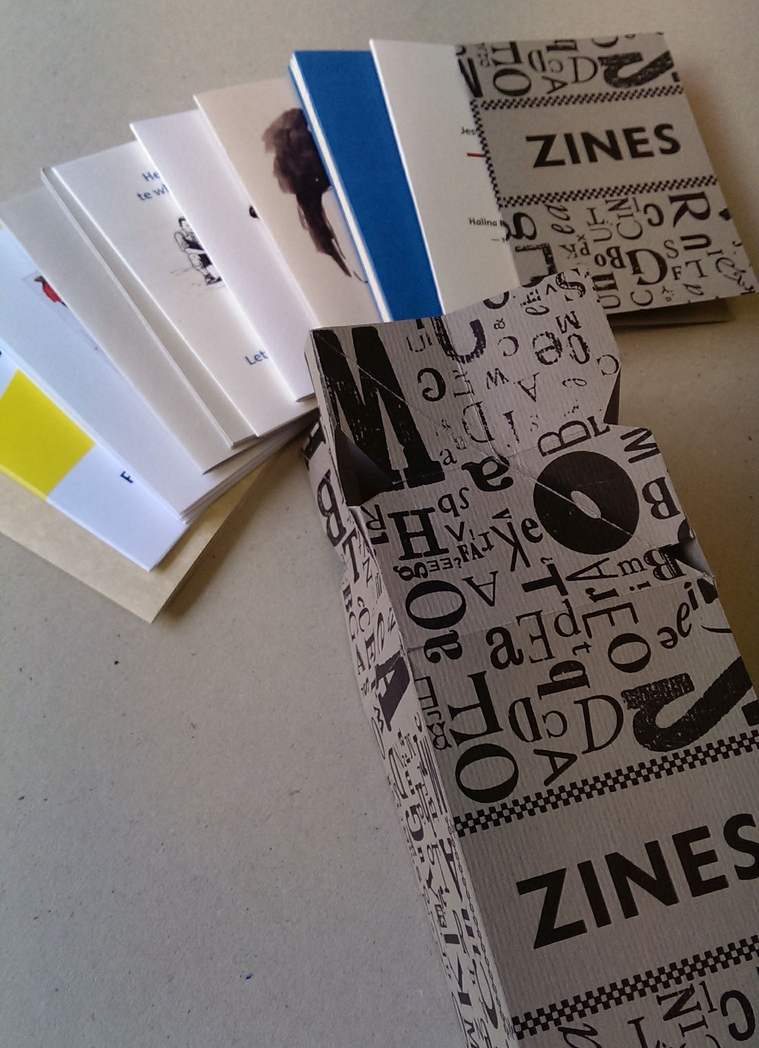 The Zine Collection box with contents spread out beside it.