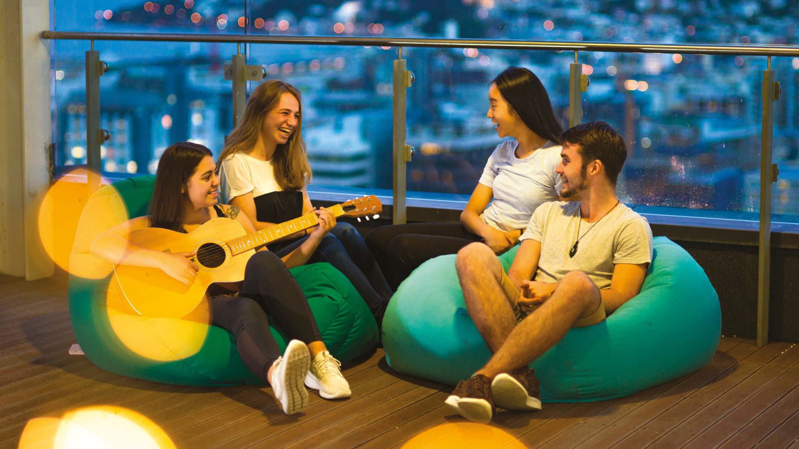 Students relaxing on bean bags on a balcony at one of University’s halls of residence.