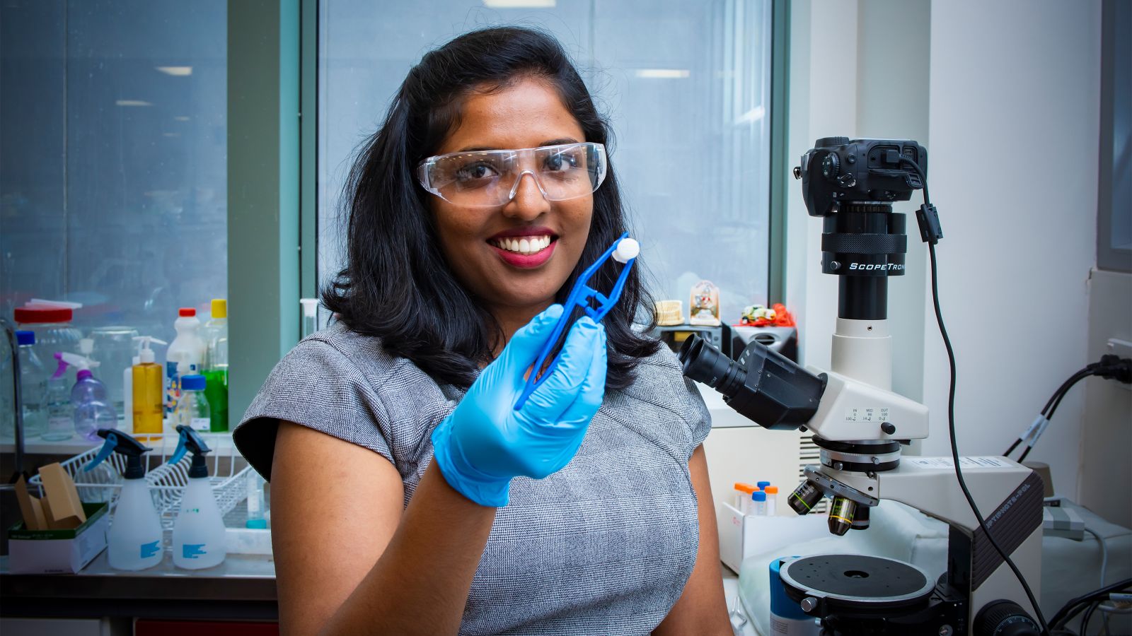 Mima Kurian in a lab with holding up one of her 3D printed structures